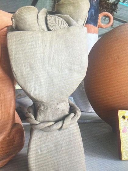 A small, raw clay sculpture of a bouquet of flowers. Even in its simplest form, the texture and shape are so beautiful.