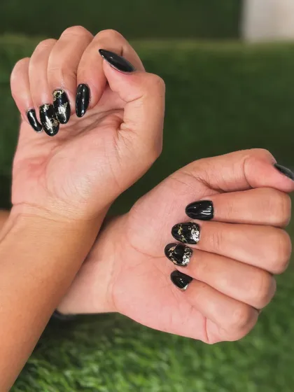 For a touch of drama, I created this look using a glossy black gel polish on almond-shaped nails. The accent nails feature a shattered gold and silver foil design for an edgy yet glamorous effect.
