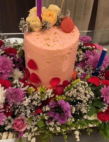 Gifting in style. This birthday cake platter features a beautiful mix of roses and chrysanthemums, creating a lush floral base for the main dessert.