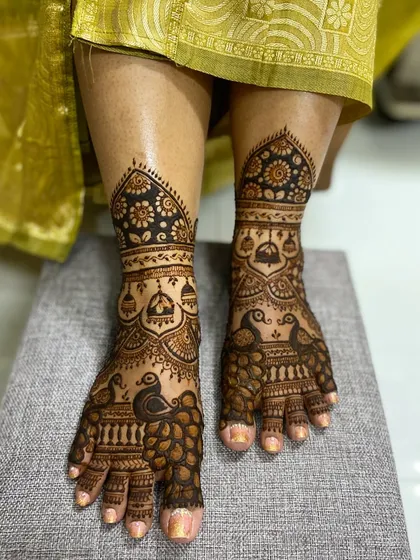 A full view of the peacock and jhumka foot mehandi, showcasing the beautiful flow of the design from the toes to the ankle.