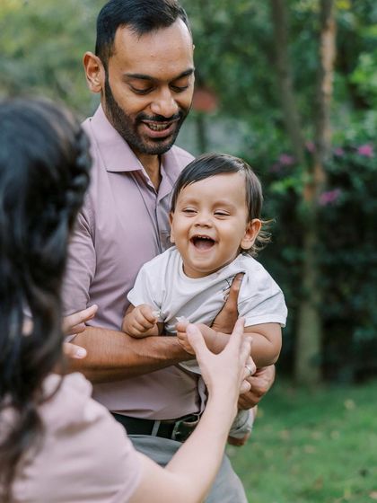 A baby laughing with joy as his parents play with him. These are the moments that you'll want to remember forever.