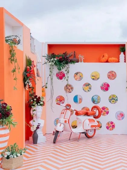Creating a stylish and relaxed atmosphere for a corporate social event. This 'Orange Hour' lounge featured a fun photo booth with a custom-painted scooter, vibrant colors, and a chevron floor, proving that professional events can be full of personality and warmth.