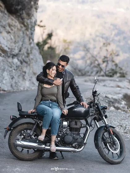 A romantic moment on a motorcycle, set against the rocky cliffs of a mountain road. I focus on capturing the connection between the couple, even in a themed shoot like this.