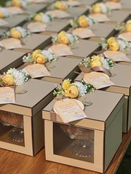 Another beautiful set of baby announcement favours. These kraft-style boxes are decorated with yellow and white floral arrangements and a personalized tag celebrating the upcoming arrival of "Baby Sethi".