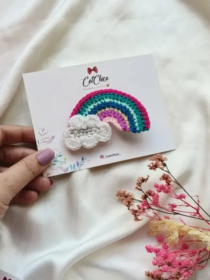 Holding our beautiful crochet rainbow and cloud clip. It's a classic design that is always popular.