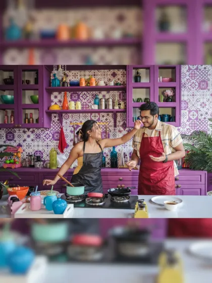 Cooking up some love! A playful and candid shot of a couple having fun in a vibrant, colorful kitchen, showing that the best moments are often the ones spent doing everyday things together.