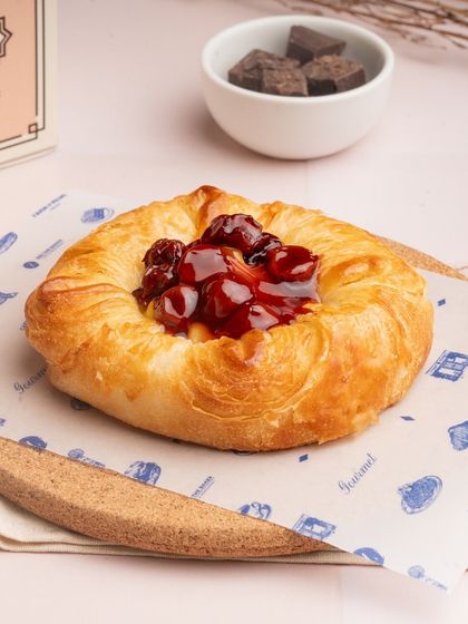 My seasonal fruit danish is a beautiful pastry. A buttery, flaky base is filled with cream and topped with fresh, vibrant cherries.