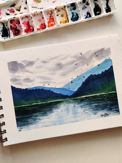Browsing through an old sketchbook, I found this peaceful lake and mountainscape I painted last year. The cool blues and greens create such a serene feeling.
