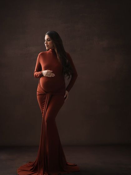 A classic and elegant pose. This three-quarter portrait in a form-fitting brown gown beautifully highlights the curves and glow of pregnancy.