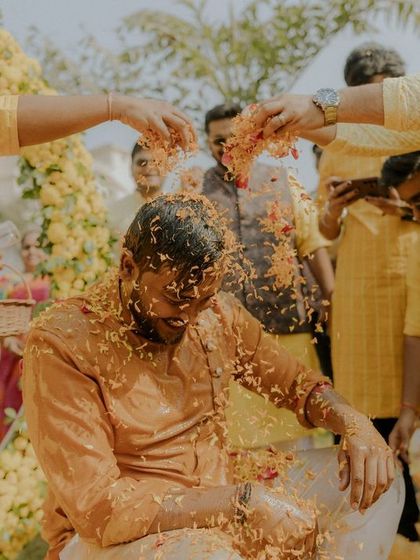 The groom gets a shower of flower petals from his friends, a classic moment of celebration during the Haldi.