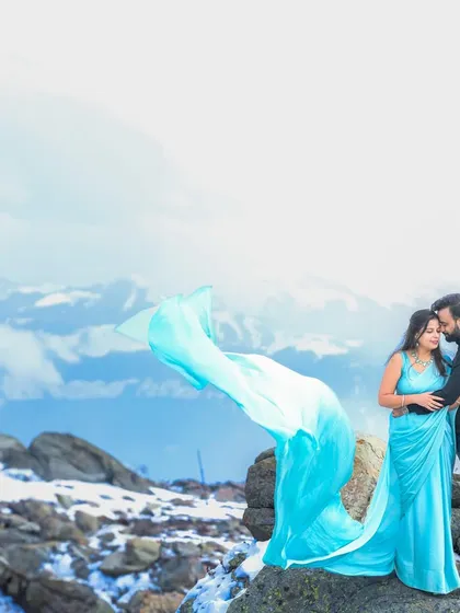 A breathtaking pre-wedding portrait in Gulmarg, Kashmir, with the snowy mountains creating a dramatic backdrop. This shot captures the epic scale and romance of a destination shoot.