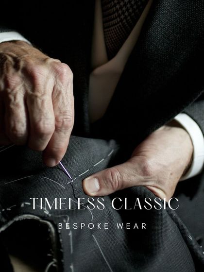 The hands of a master tailor hand-stitching a lapel. This traditional technique, known as basting, is essential for shaping the garment perfectly to the client's form.