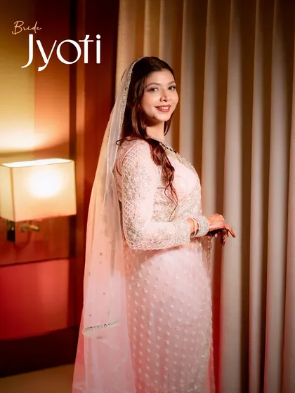 A soft and elegant portrait of the bride, Jyoti. The warm, gentle lighting complements her pastel outfit and creates a feeling of serene happiness.