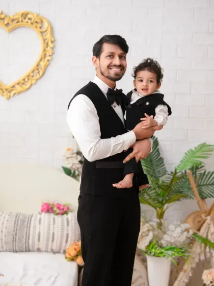 A proud father and his son, dressed in matching formal vests. This portrait highlights the special bond between them in a classic and elegant style.