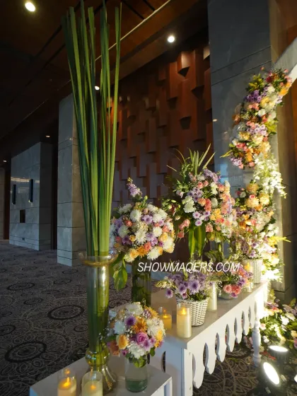 A side view of the entrance decor, showcasing lush floral arrangements and tall glass vases with greenery.