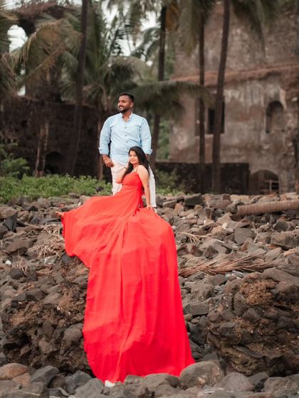 Love on the rocks. This couple's beach pre-wedding shoot is made more dramatic with the vibrant red gown flowing over the landscape.