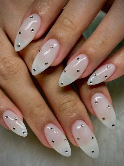 Diamond-drop elegance for the minimalist bride. This design features a soft, milky white ombré on a long almond shape, with tiny, perfectly placed silver studs for a subtle yet luxurious sparkle.