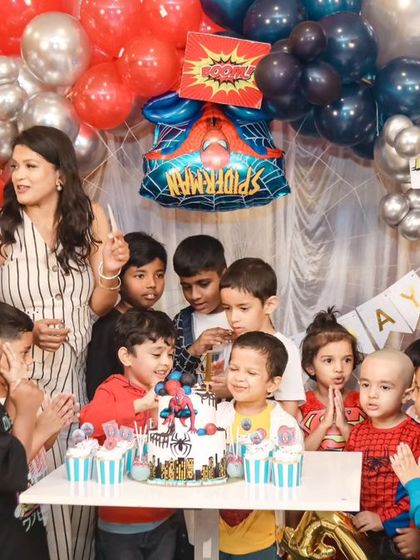 A thrilling 'Spiderman' themed birthday party, with red and blue decor, spiderweb props, and a cityscape backdrop, ready for web-slinging action.
