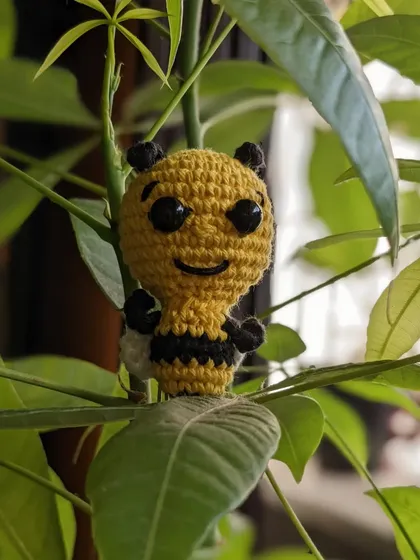 The honey bee bookmark sitting playfully on a plant.