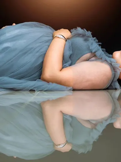 A close-up of the artistic reflection portrait, focusing on the peaceful expression of the mom-to-be. This shot emphasizes the tranquility and inner glow of pregnancy in a fine art style.