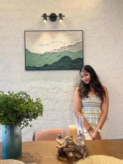 Here I am with a recently installed textured artwork in a client's home. The subtle green hues and mountain-like texture create a serene and natural focal point for their dining space.