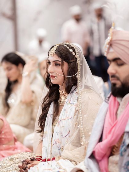 A candid moment from the Anand Karaj ceremony. The makeup is designed to look beautiful and serene both in person and in photographs, capturing the sanctity of the moment.