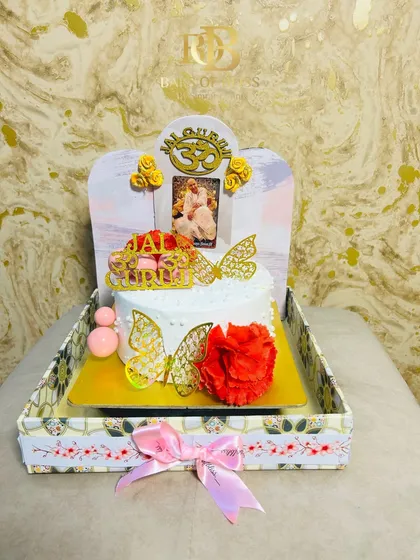 A divine tray cake created for a Guruji's birthday celebration. This half-kilogram cake is decorated with a photo, the 'Om' symbol, and beautiful butterfly accents.