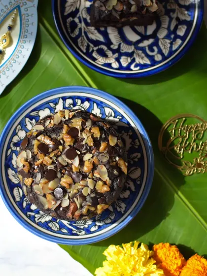 A slice of my Ragi Chocolate Walnut Cake served on a beautiful blue plate, perfect for a healthy Rakhi celebration.