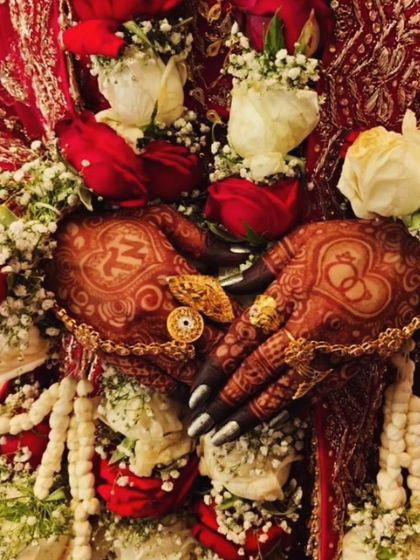 An engagement design with interlocking rings and the initials 'MM', surrounded by floral jewelry.