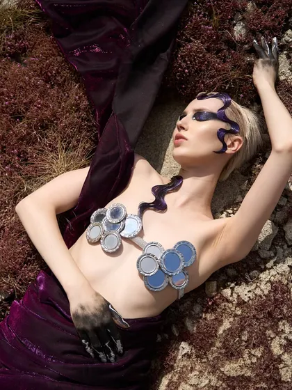 This reclining pose from the 'Siren' shoot shows the makeup from a different angle, with the dark, painted hand adding to the narrative.