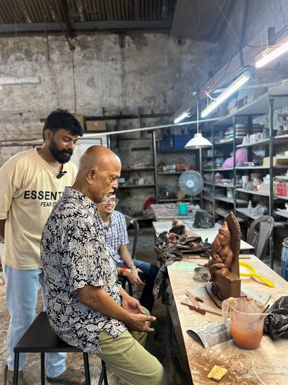 I am watching over a student as he puts the finishing touches on his Ganesha idol. It's a moment of shared creation and passing on a tradition.