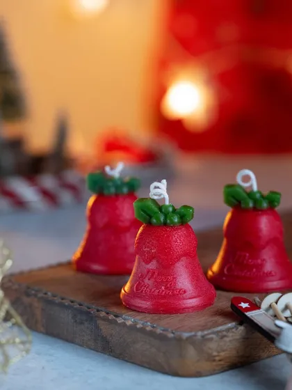 Jingle all the way with these cute Christmas bell-shaped candles. They look adorable on a wooden board as part of a festive display.
