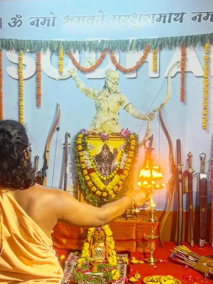 I perform 'aarati', offering the light of the sacred flame to the deities and the revered weapons. This ritual is a prayer for enlightenment and a symbol of the divine knowledge we seek to attain.