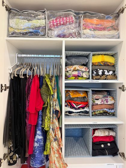 We create zones for different types of clothing. Here, hanging items are separated from folded clothes stored in bins and clear-front bags, creating a system that's easy to navigate.