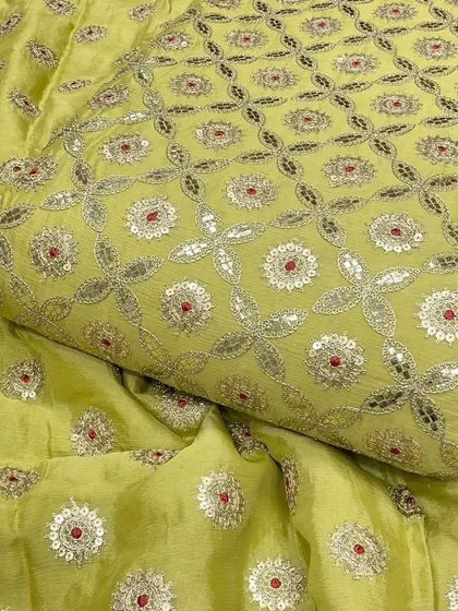 A closer look at the beautiful Gotta Patti embroidery on this lime green Chinon fabric. The combination of silver threadwork, sequins, and a pop of red creates a fresh and festive look.