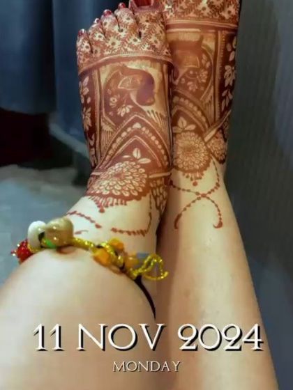 A close-up of a bride's feet, adorned with beautiful mehndi, showcasing the final dark stain.