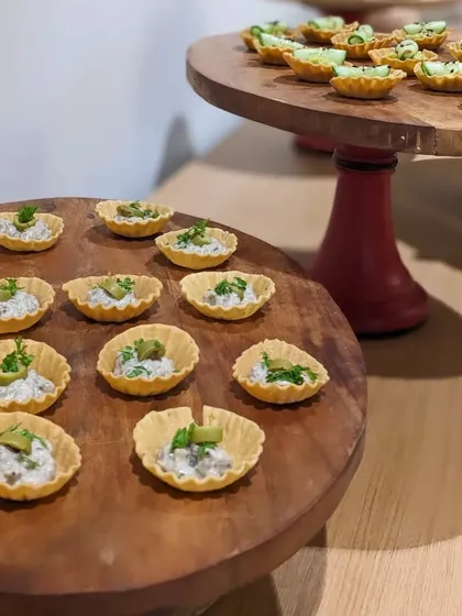 Mushroom tarts served on rustic wooden boards. These bite-sized pastries are filled with a savory mushroom ragout, perfect for passing around at a corporate mixer.