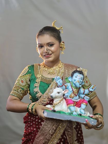 A classic portrait for Ganesh Chaturthi, featuring a traditional Nauvari and a beautiful Ganpati murti.
