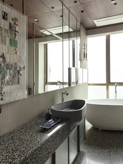 A view of the daughter's bathroom from the Elle Decor feature. The image captures the serene combination of the freestanding tub, concrete basin, and the light-filled space.