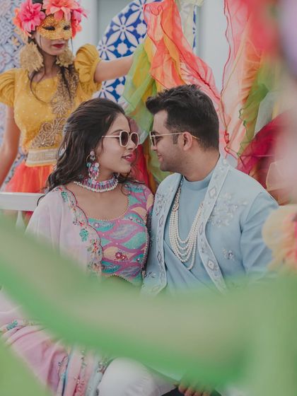 A candid moment between the couple at their colorful, carnival-themed event. Their shared look speaks of a deep connection and shared joy.