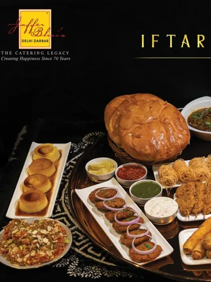 A beautifully composed shot of our Iftar platter, highlighting the variety of textures and colours, from crispy fried items to creamy desserts and savory kebabs.