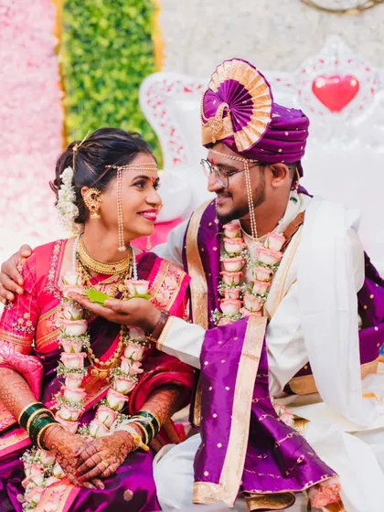 A tender moment during a Maharashtrian wedding, showcasing the beautiful bond between the couple. The groom's admiration and the bride's joyful expression are the focus of this candid shot.