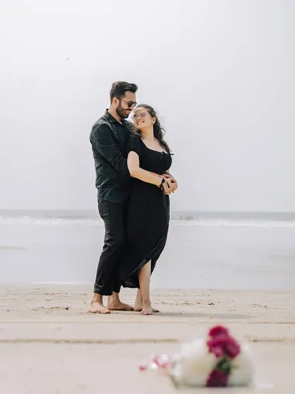 A romantic embrace on the sand with a bouquet of flowers in the foreground. This shot uses depth to create a beautiful and intimate beach portrait.