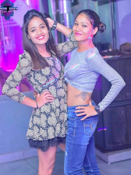 Two friends posing on the dance floor. The vibrant lighting and energetic music make for great photo opportunities and even better memories.