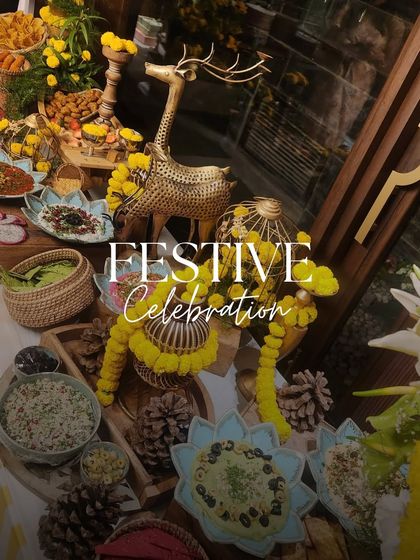 A festive celebration table adorned with marigolds and golden decor. This setup for a Rakhi or Teej party features a beautiful spread of Mediterranean and Indian dips and snacks.