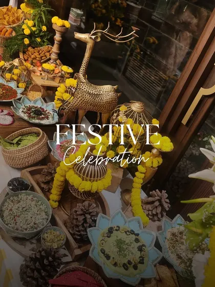 A festive celebration table adorned with marigolds and golden decor. This setup for a Rakhi or Teej party features a beautiful spread of Mediterranean and Indian dips and snacks.