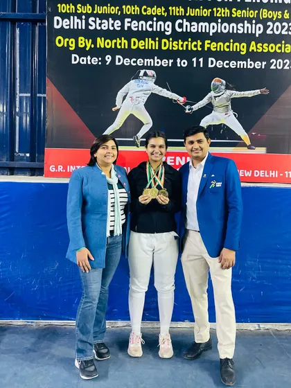 A double gold medalist from the senior women's category, flanked by her proud coaches at the Delhi State Championship.
