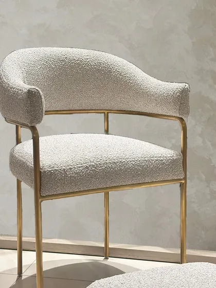 The full view of the bouclé chair and footrest, showcasing its elegant proportions and the balance of modern sophistication and functional design.
