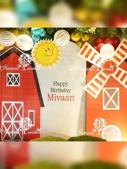A close-up of the barn and windmill backdrop, highlighting the sunny and cheerful details of this farm-themed decor.