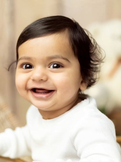 A detailed close-up of a baby's joyful expression. We focus on capturing these fleeting moments of pure happiness.